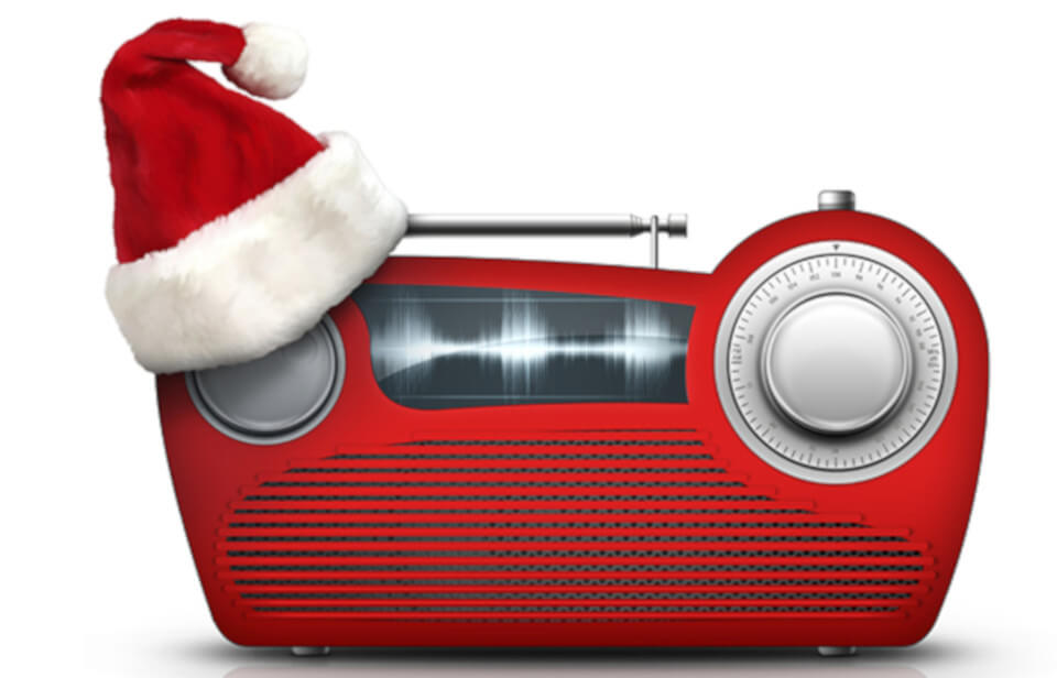 An old school red radio wearing a christmas hat