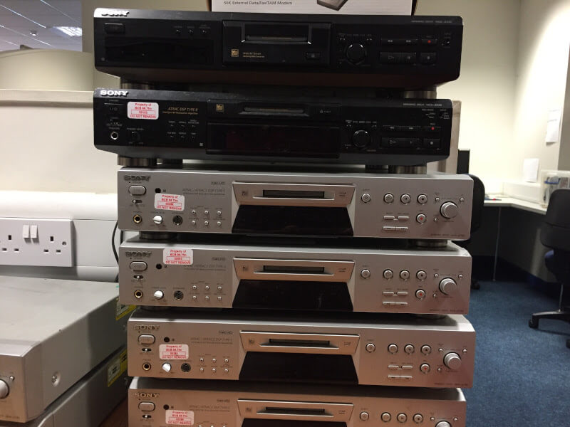 a stack of worn-looking minidisc players